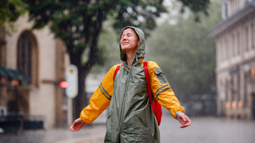 Person walking outdoors after rainfall, experiencing petrichor