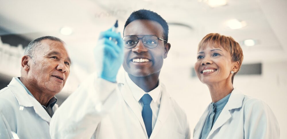Three scientists in a laboratory examining a sample together
