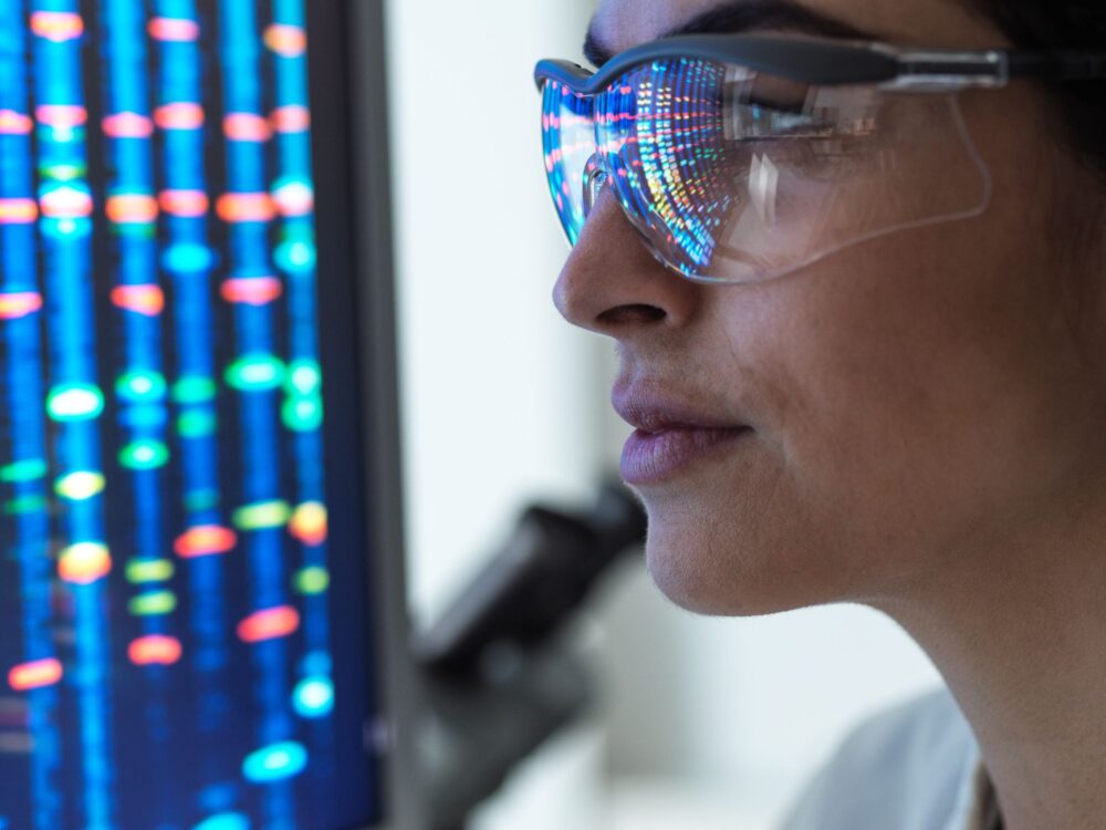 Scientist examining genetic sequencing data on a screen